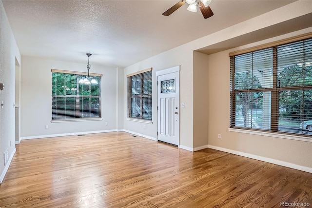 10193 E 29th Ave, Denver, CO 80238 - unfurnished room with light wood-type flooring, a chandelier, a ceiling fan, and a textured ceiling