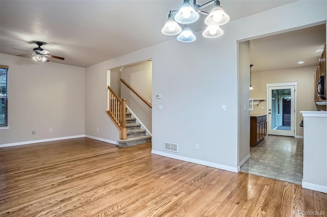 10193 E 29th Ave, Denver, CO 80238 - spare room with a ceiling fan, stairs, light wood finished floors, and a chandelier