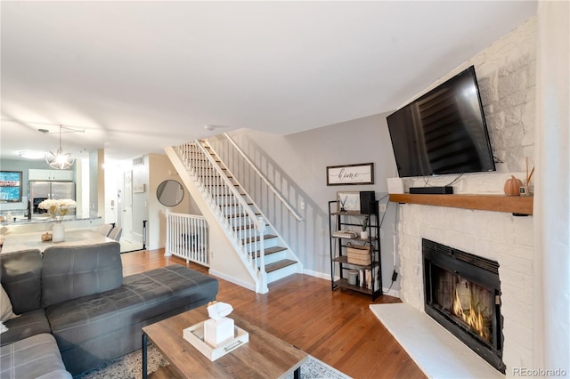 8787 W Cornell Ave Unit 6, Lakewood, CO 80227 - living area with stairs, a stone fireplace, wood finished floors, and baseboards