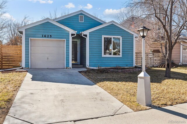 view of front facade with an attached garage, fence, concrete driveway, and a front yard