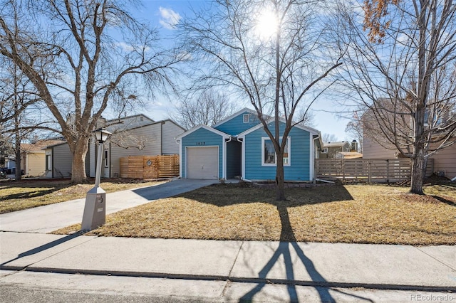 view of front of house with a garage, driveway, a front lawn, and fence