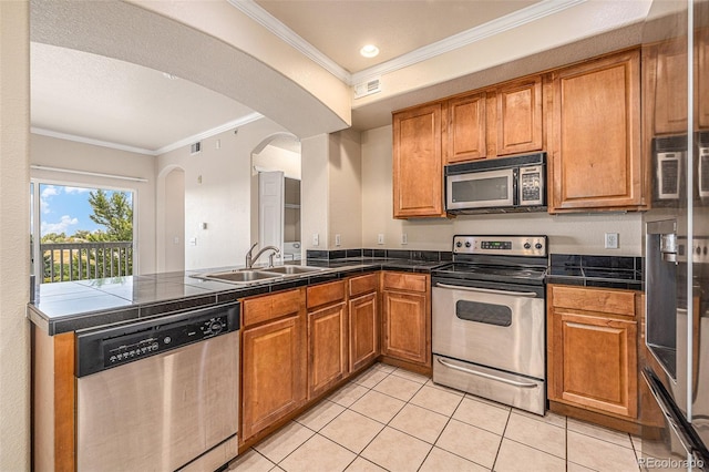 kitchen featuring light tile patterned floors, stainless steel appliances, ornamental molding, and sink