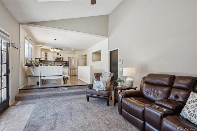 living room with a chandelier, lofted ceiling, light tile patterned flooring, and recessed lighting