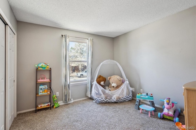 rec room featuring a textured ceiling, carpet flooring, and baseboards