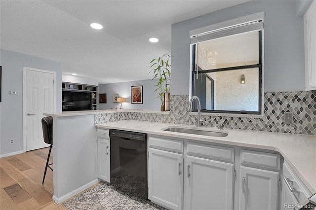 kitchen with dishwasher, light hardwood / wood-style flooring, tasteful backsplash, and sink