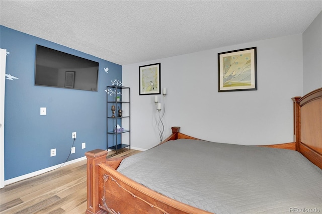 bedroom featuring light hardwood / wood-style flooring and a textured ceiling