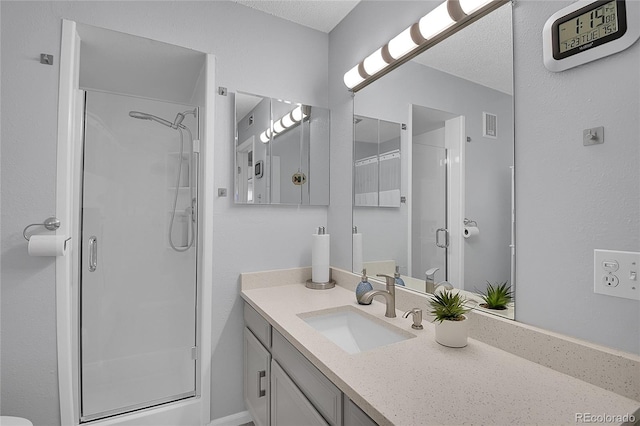 bathroom featuring vanity, an enclosed shower, and a textured ceiling