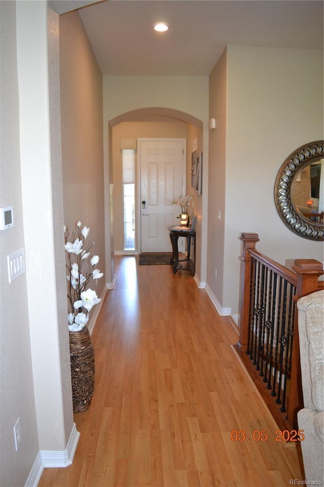 7851 E 148th Dr, Thornton, CO 80602 - corridor with baseboards, arched walkways, and light wood-style flooring