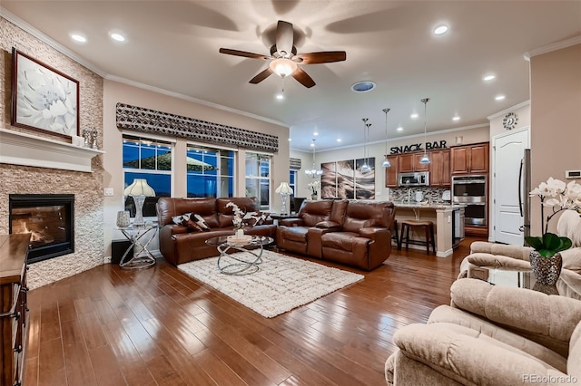 7851 E 148th Dr, Thornton, CO 80602 - living room with dark wood-type flooring, a ceiling fan, a stone fireplace, and ornamental molding