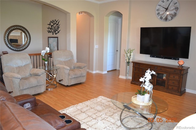 7851 E 148th Dr, Thornton, CO 80602 - living area featuring arched walkways, baseboards, visible vents, and wood finished floors