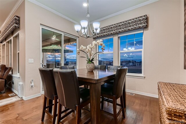 7851 E 148th Dr, Thornton, CO 80602 - dining room with crown molding, baseboards, a notable chandelier, and wood finished floors