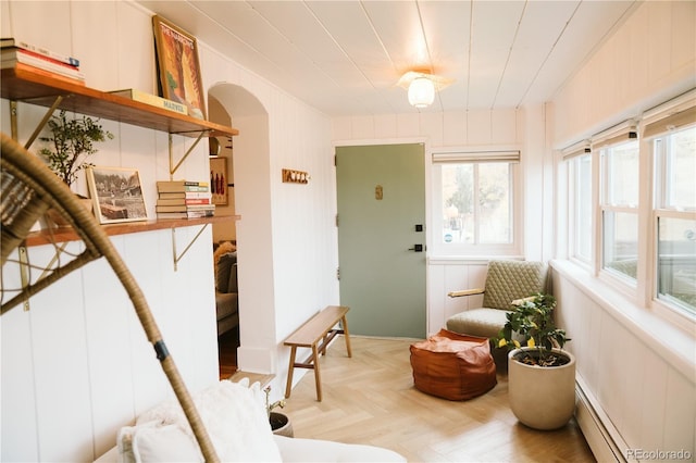 interior space featuring arched walkways and a baseboard radiator