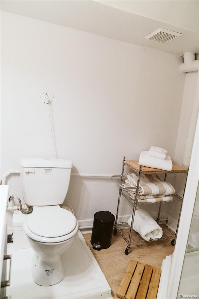 bathroom with toilet, wood finished floors, and visible vents