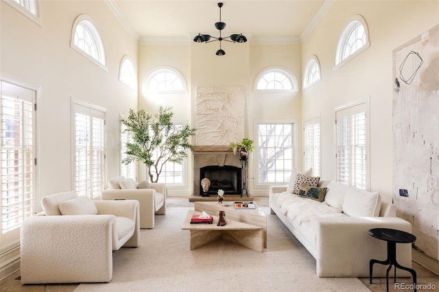 living room with a high ceiling, crown molding, and an inviting chandelier