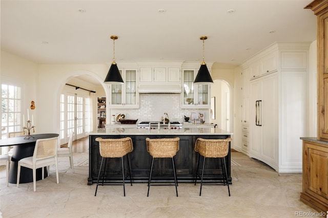 5700 S Steele St, Greenwood Village, CO 80121 - kitchen with arched walkways, decorative backsplash, glass insert cabinets, decorative light fixtures, and recessed lighting
