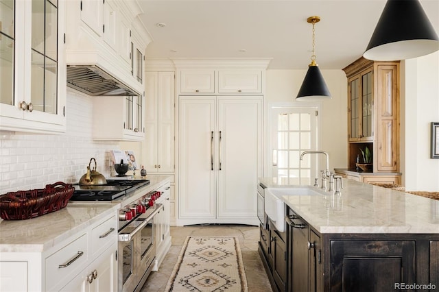 5700 S Steele St, Greenwood Village, CO 80121 - kitchen featuring high quality appliances, custom exhaust hood, tasteful backsplash, a kitchen island with sink, and white cabinetry