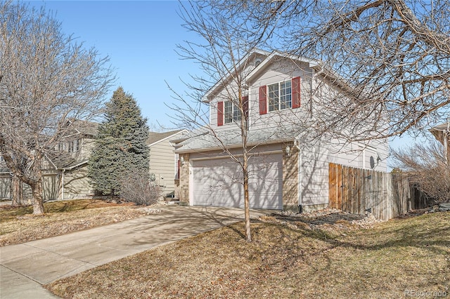 view of front of property featuring driveway, an attached garage, fence, and a front lawn