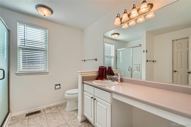 full bathroom with visible vents, toilet, a stall shower, vanity, and baseboards