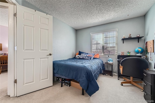 bedroom featuring light carpet and a textured ceiling