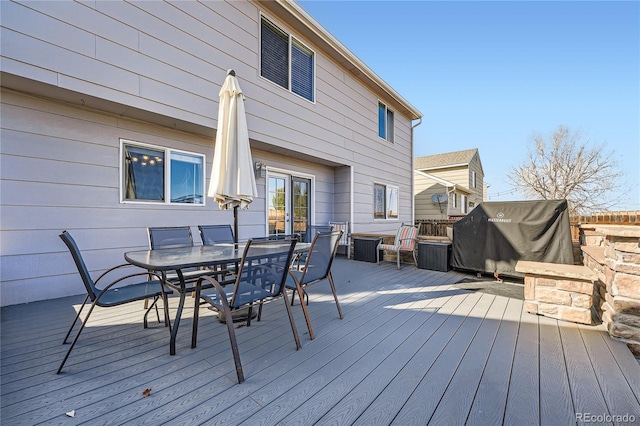 deck with outdoor dining space and a grill