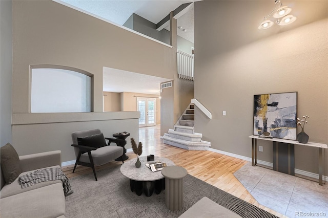 5130 S Wenatchee St, Aurora, CO 80015 - living room featuring stairway, wood finished floors, baseboards, a towering ceiling, and french doors