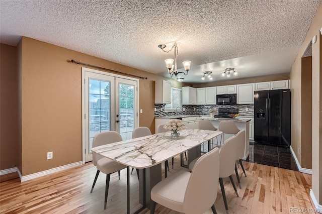 5130 S Wenatchee St, Aurora, CO 80015 - dining area featuring a textured ceiling, light wood-style floors, baseboards, and a chandelier