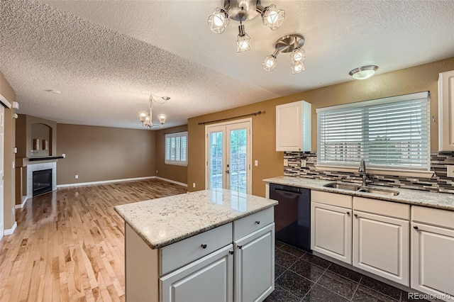5130 S Wenatchee St, Aurora, CO 80015 - kitchen with dishwasher, a sink, a chandelier, a textured ceiling, and backsplash