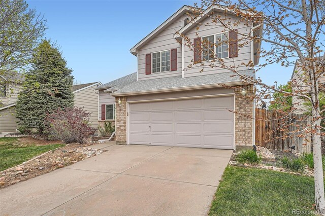 5130 S Wenatchee St, Aurora, CO 80015 - traditional-style house with concrete driveway, an attached garage, fence, brick siding, and a shingled roof