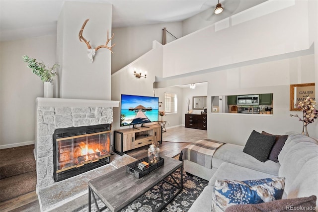 3600 S Pierce St Unit 7-208, Denver, CO 80235 - living area with a stone fireplace, high vaulted ceiling, and a ceiling fan