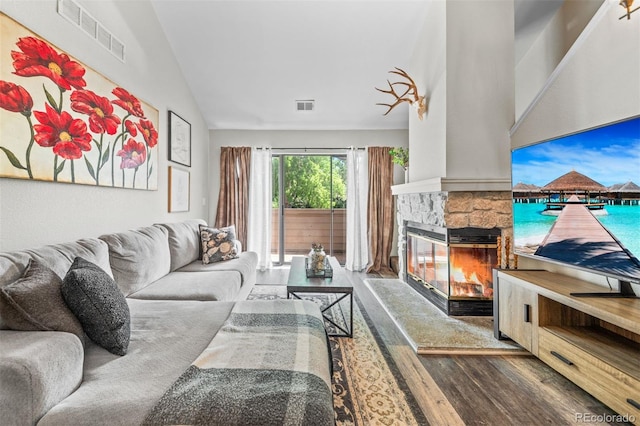 3600 S Pierce St Unit 7-208, Denver, CO 80235 - living room with wood finished floors, a stone fireplace, and vaulted ceiling