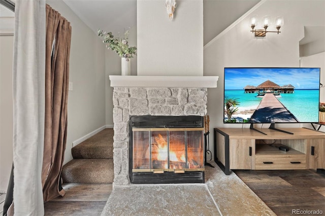 3600 S Pierce St Unit 7-208, Denver, CO 80235 - living area with wood finished floors, a stone fireplace, and vaulted ceiling