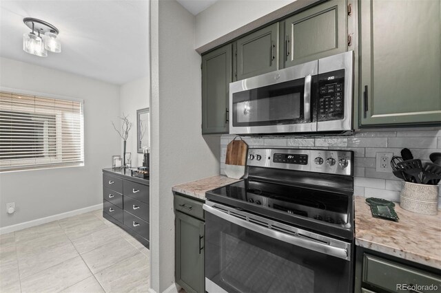3600 S Pierce St Unit 7-208, Denver, CO 80235 - kitchen featuring stainless steel appliances, tasteful backsplash, light tile patterned floors, and light stone countertops