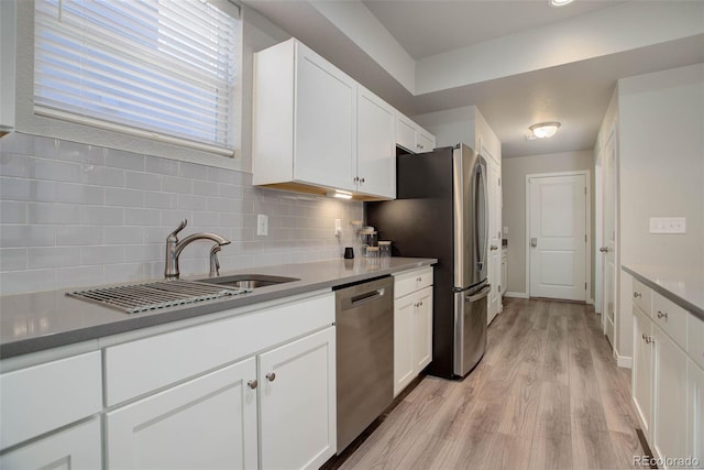 kitchen featuring stainless steel appliances, tasteful backsplash, sink, and white cabinets