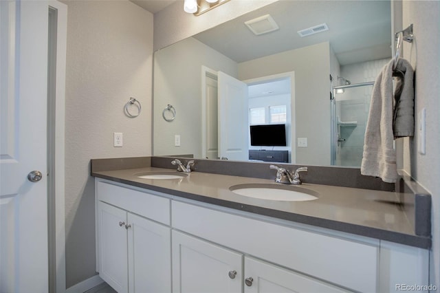 bathroom with vanity and a shower with shower door