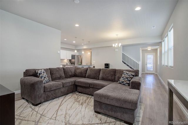 living room featuring a chandelier and light hardwood / wood-style floors