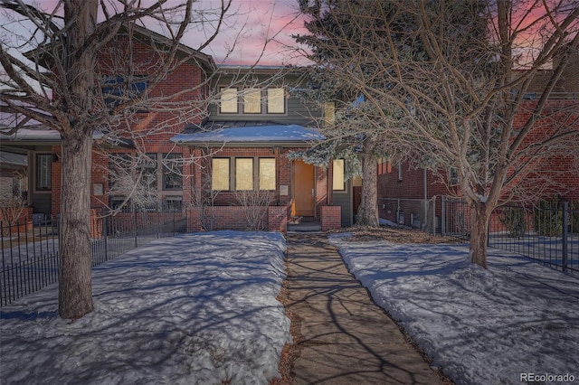 view of front of property with brick siding and fence