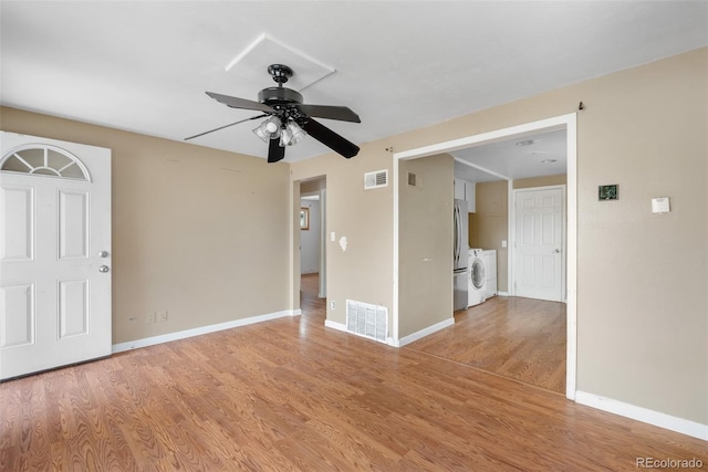 6150 E 65th Ave, Commerce City, CO 80022 - spare room featuring separate washer and dryer, light wood finished floors, and a ceiling fan