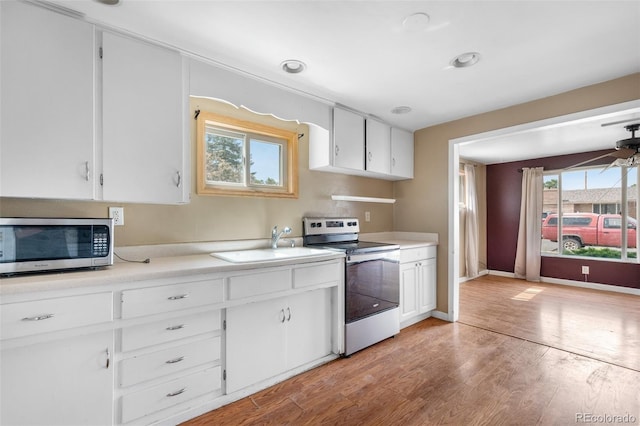 6150 E 65th Ave, Commerce City, CO 80022 - kitchen featuring stainless steel appliances, light wood-type flooring, light countertops, and white cabinets