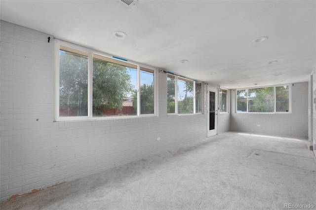 6150 E 65th Ave, Commerce City, CO 80022 - unfurnished sunroom with brick wall, carpet floors, and recessed lighting
