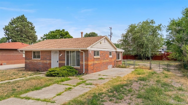 6150 E 65th Ave, Commerce City, CO 80022 - rear view of property featuring brick siding, roof with shingles, and a gate