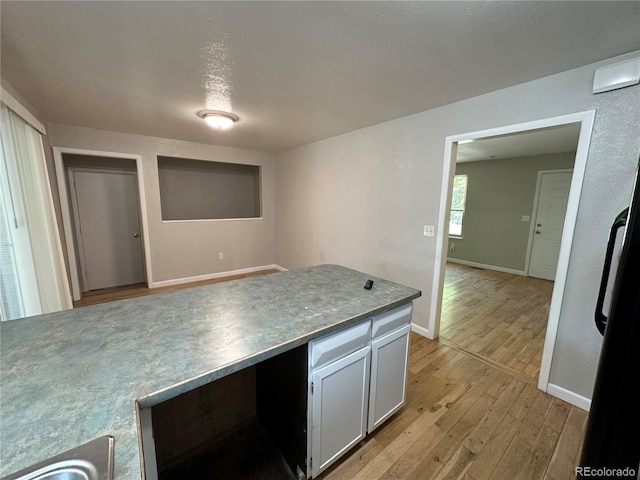 kitchen featuring white cabinets and light hardwood / wood-style flooring