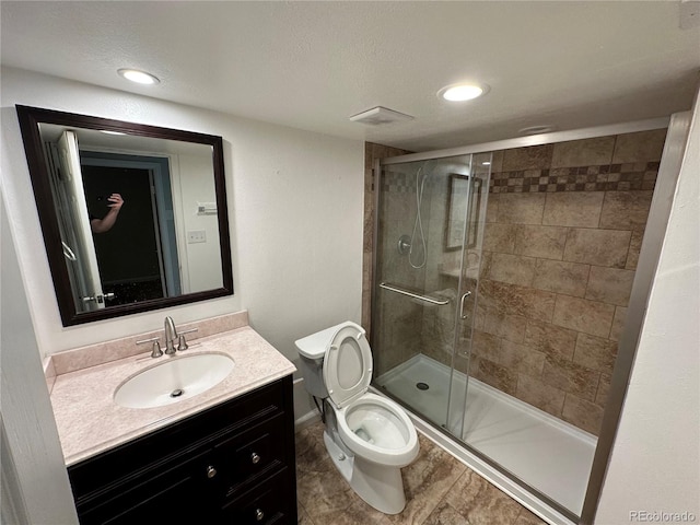 bathroom featuring walk in shower, tile floors, a textured ceiling, toilet, and vanity with extensive cabinet space