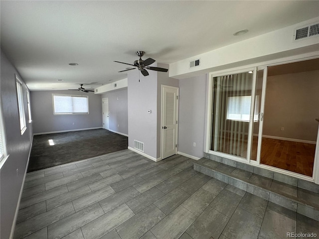 spare room with dark carpet and ceiling fan