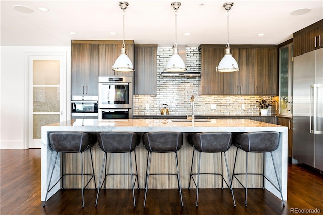 1133 14th St Unit 4150, Denver, CO 80202 - kitchen featuring stainless steel appliances, tasteful backsplash, a center island with sink, a breakfast bar, and recessed lighting