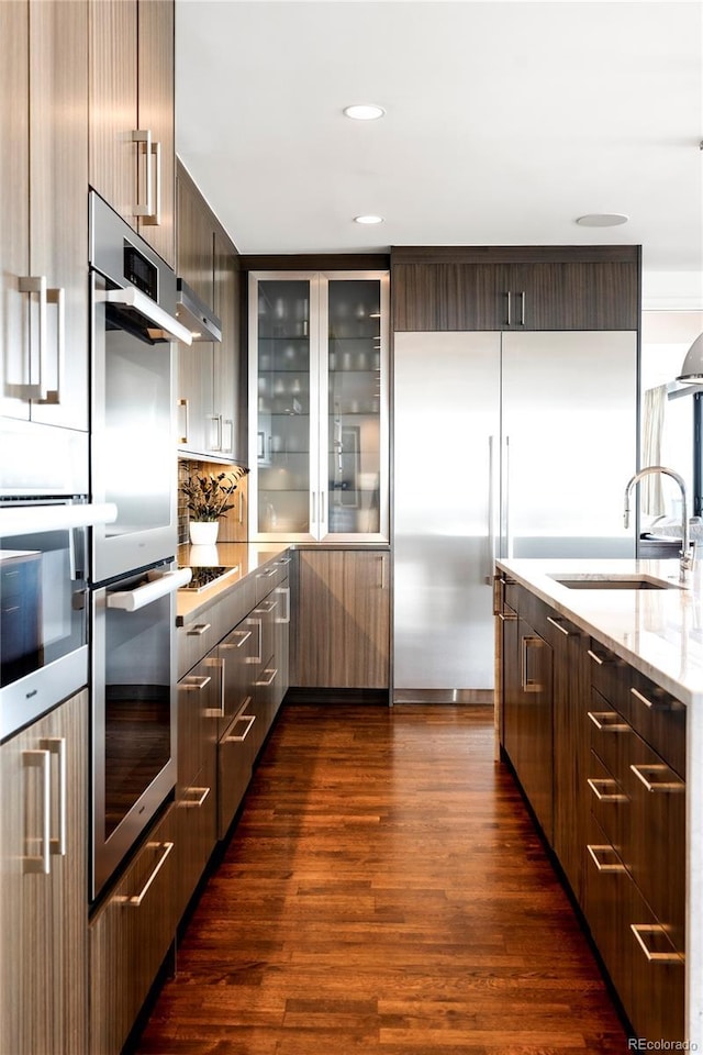 1133 14th St Unit 4150, Denver, CO 80202 - kitchen with stainless steel appliances, modern cabinets, dark wood-style flooring, light stone countertops, and recessed lighting