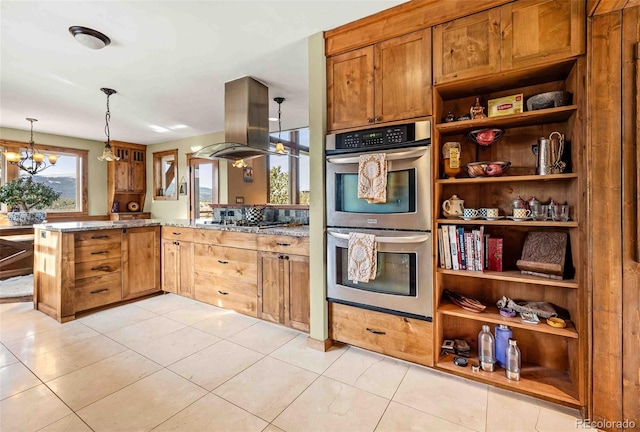 kitchen with island exhaust hood, kitchen peninsula, appliances with stainless steel finishes, pendant lighting, and a chandelier