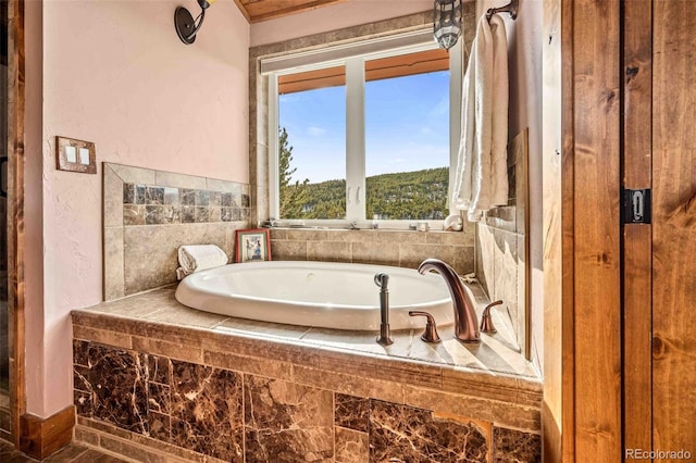 bathroom with a relaxing tiled tub