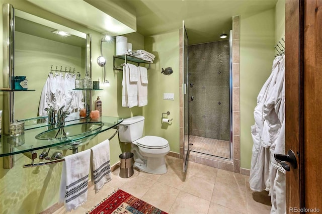 bathroom with tile patterned flooring, toilet, a shower with door, and sink