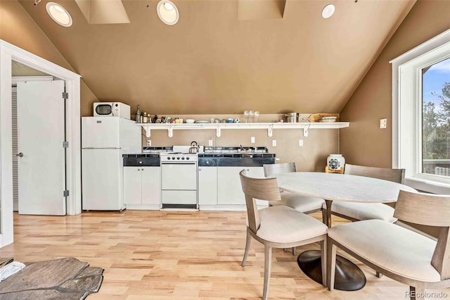 kitchen with vaulted ceiling, light hardwood / wood-style flooring, and white appliances