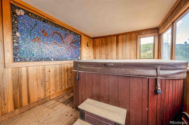 interior space with hardwood / wood-style flooring, wood walls, and a hot tub